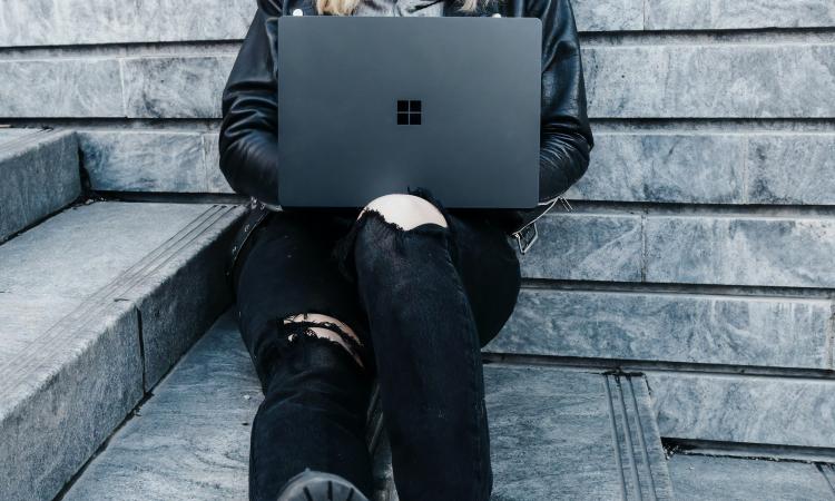 sitter med en dator i knät