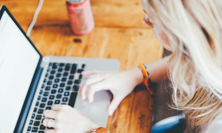 En student sitter och arbetar vid sin dator. 