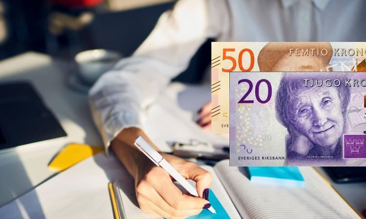 Man som skriver i en bok med pengar till höger.