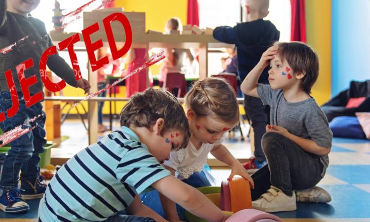 Barn leker med ett stort 'rejected' högst upp till höger